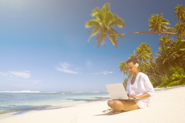 laptop sahilde bir kadınla