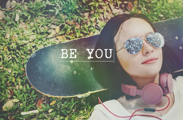 Girl lying on skateboard on background — Stock Photo, Image