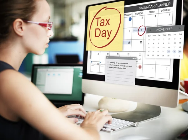 在计算机上用税一天工作的女商人 — 图库照片