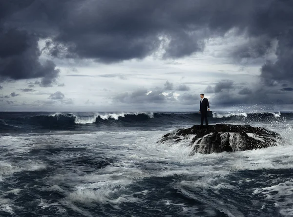 Businessman in suit standing on rock — Stock Photo, Image