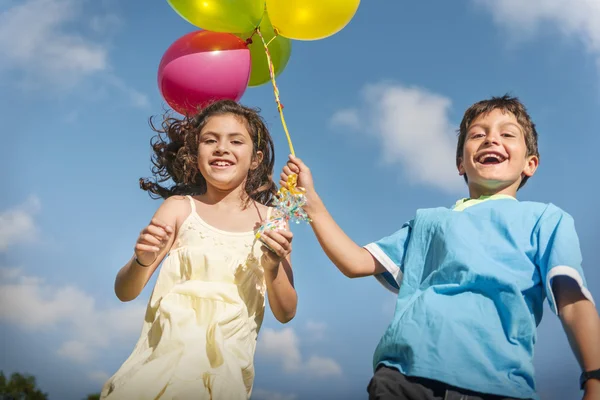 Kinder spielen mit bunten Luftballons — Stockfoto