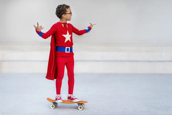 Superhjälte ungen ridning på skateboard — Stockfoto