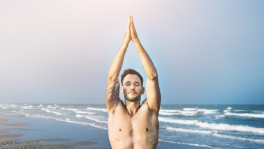 pratik Yoga plajda adam