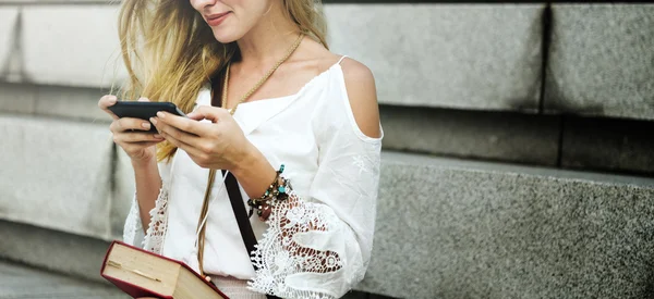 Mujer sosteniendo el teléfono inteligente en las manos — Foto de Stock