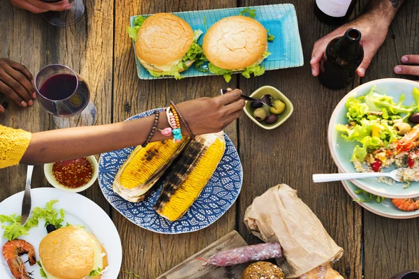 Amigos comiendo para la mesa grande —  Fotos de Stock