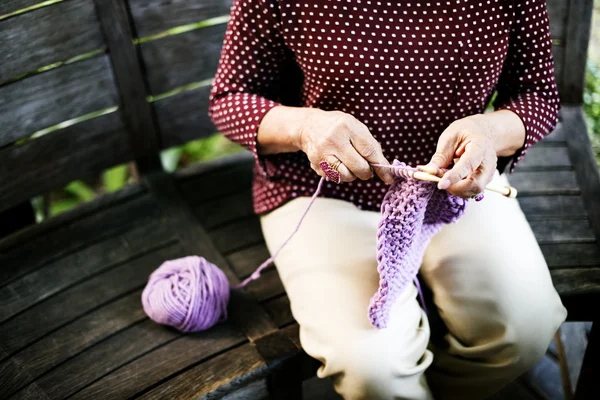 Ältere Frau strickt Schal — Stockfoto
