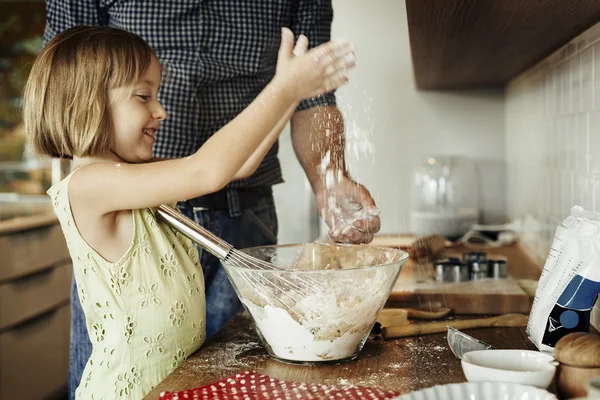 Маленькая девочка с отцом пекут печенье — стоковое фото