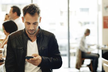 Kahve dükkanında Smartphone kullanan adam