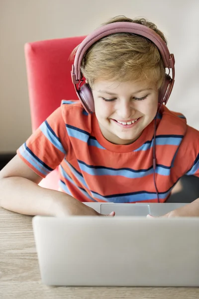 Niño con auriculares y portátil — Foto de Stock