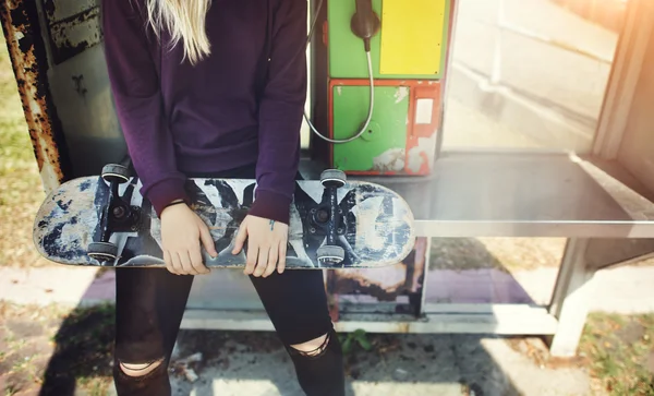 Jovem mulher segurando skate — Fotografia de Stock