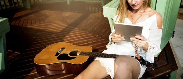 Dívka s kytarou pomocí tabletu — Stock fotografie