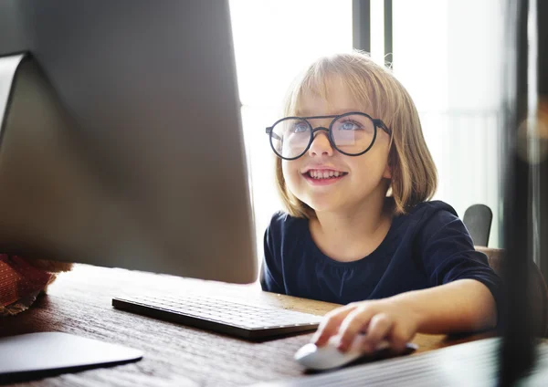 Маленькая девочка играет с компьютером — стоковое фото