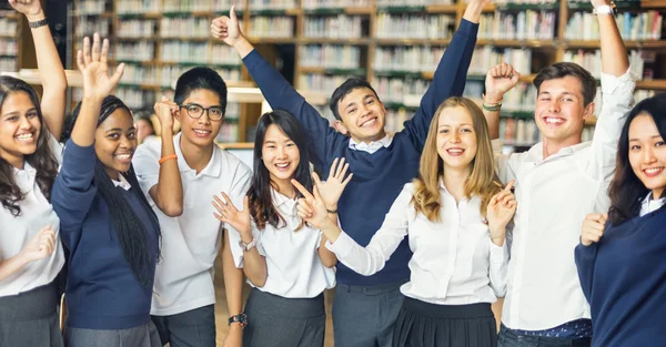 Estudantes felizes na biblioteca universitária — Fotografia de Stock