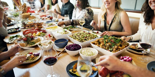 Mensen zitten aan tafel en eten — Stockfoto