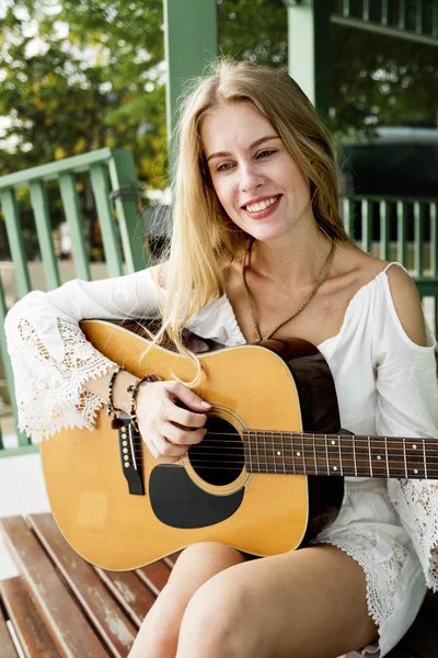 Nettes Mädchen, das draußen auf der Gitarre spielt — Stockfoto