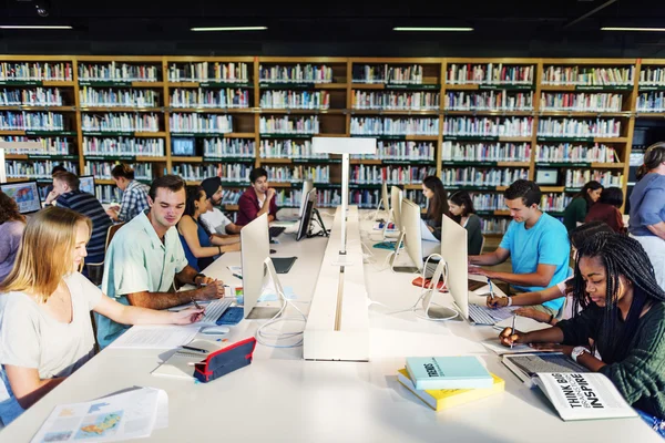 Studenter som bruker datamaskiner i universitetsbiblioteket – stockfoto