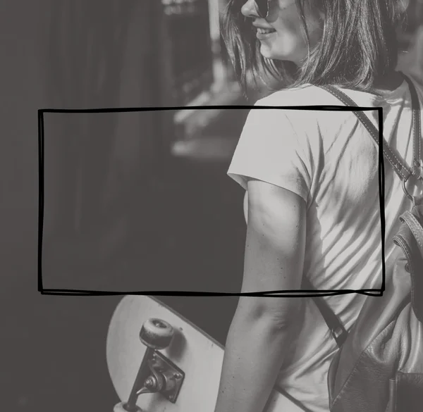 Женщина со скейтбордом на фоне — стоковое фото