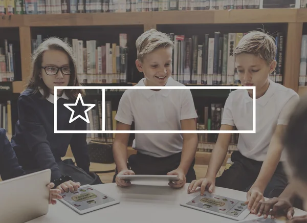 Niños con dispositivos digitales en la biblioteca —  Fotos de Stock