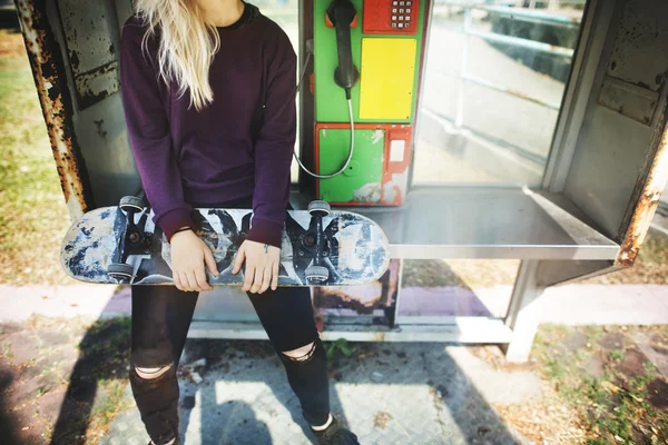 Молодая женщина держит скейтборд — стоковое фото