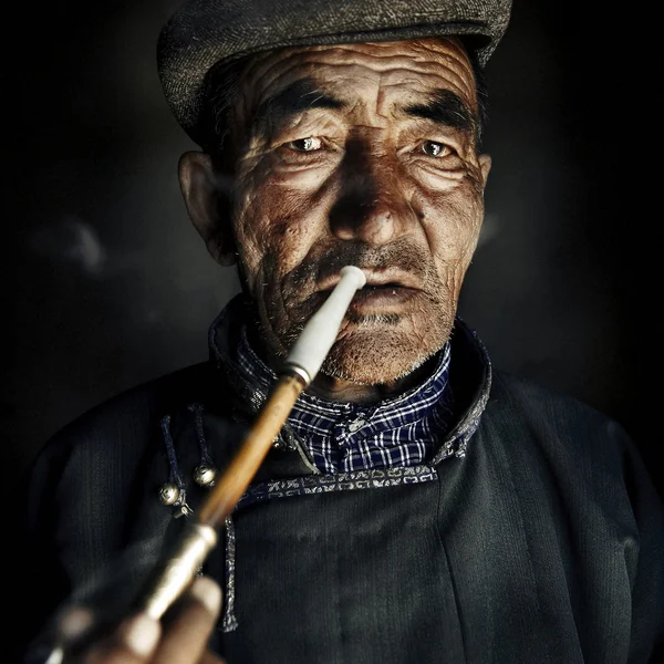 Άνθρωπος με παραδοσιακή ενδυμασία που καπνίζει έναν σωλήνα — Φωτογραφία Αρχείου