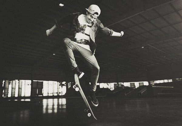 Молодой человек прыгает со скейтборда
