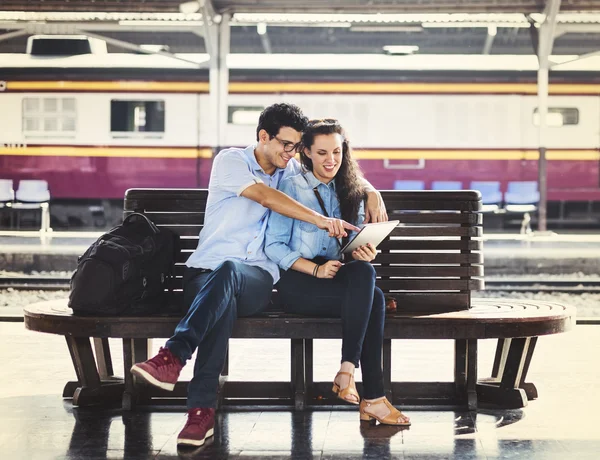 Casal senta-se na estação — Fotografia de Stock