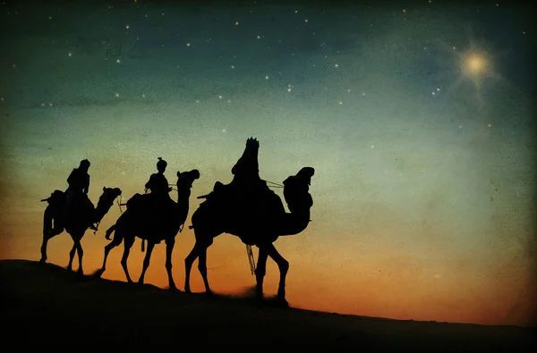 Hommes chevauchant des chameaux à travers le désert — Photo