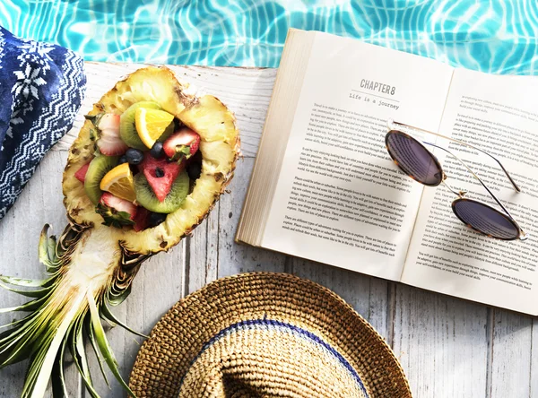 Book and fruits poolside — Stock Photo, Image