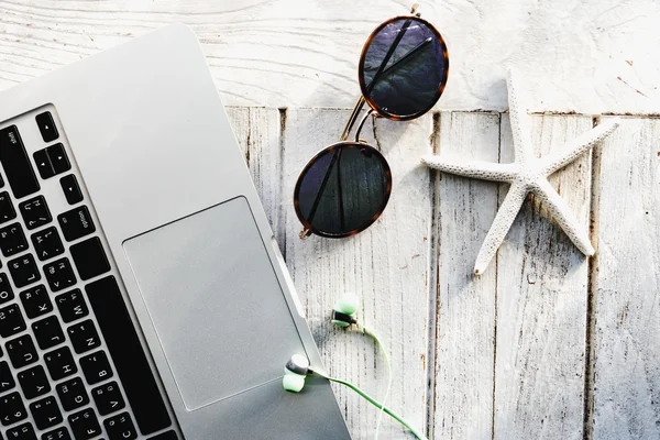 Ноутбук, сонцезахисні окуляри і Seashell на столі — стокове фото