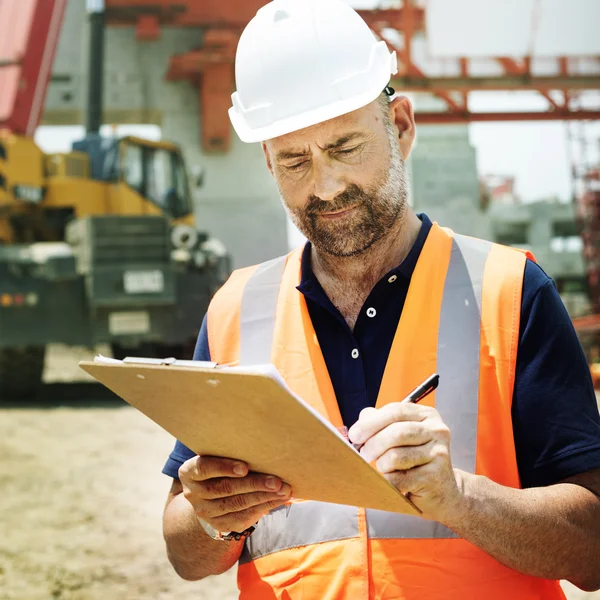 Trabajador de la construcción mirando a Business Plann — Foto de Stock