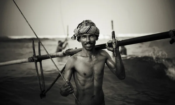 Ein Fischer wirft sein Netz aus einem traditionellen Boot am