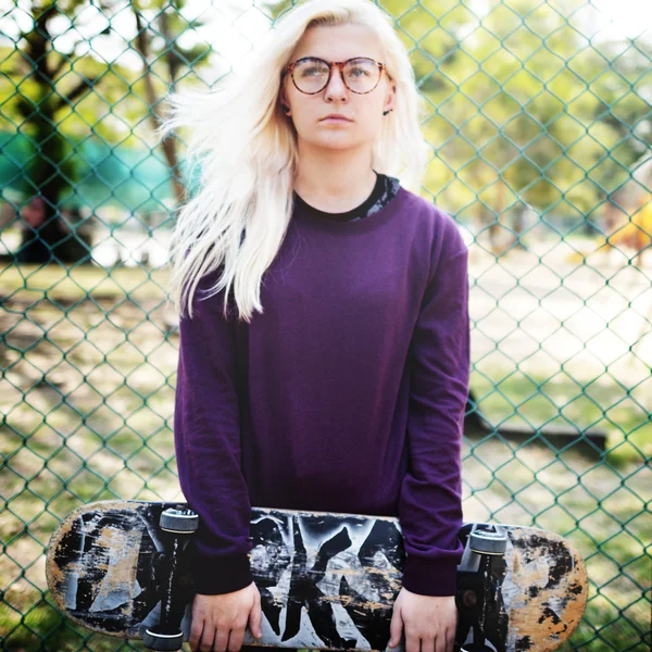 Blond tjej anläggning skateboard — Stockfoto