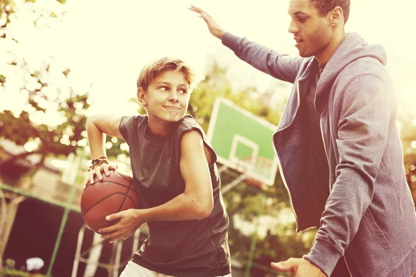 Sportsman enseigner garçon jouer au basket-ball — Photo