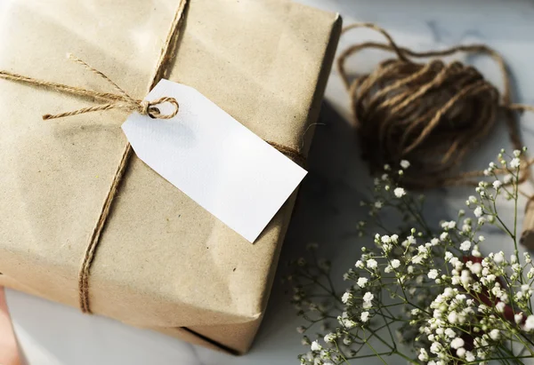 Gift and white flowers on table