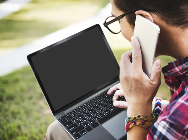 Άνθρωπος με laptop μιλάτε στο τηλέφωνο — Φωτογραφία Αρχείου