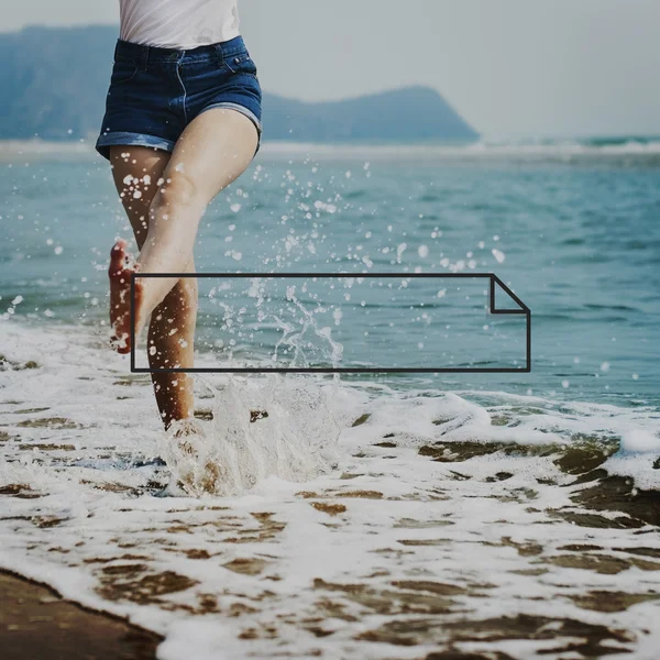 Vrouw spetterend water op strand — Stockfoto