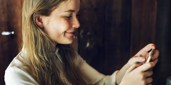 Ung flicka med telefonen i café — Stockfoto