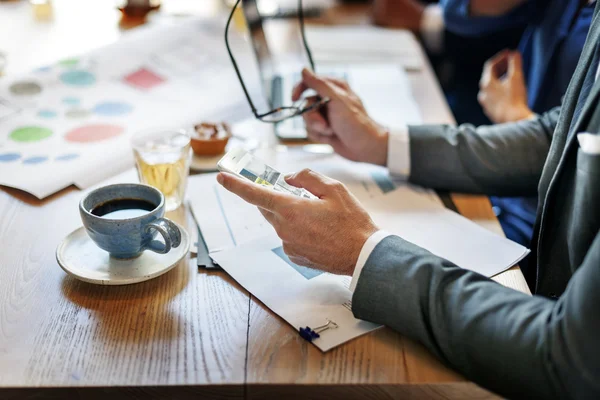 Empresário usando smartphone durante a reunião — Fotografia de Stock