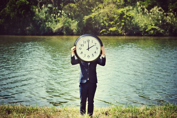 Geschäftsmann im Freien hält Uhr an — Stockfoto