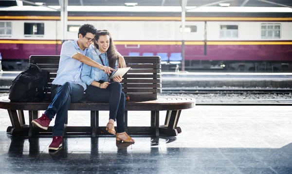 Casal senta-se na estação — Fotografia de Stock