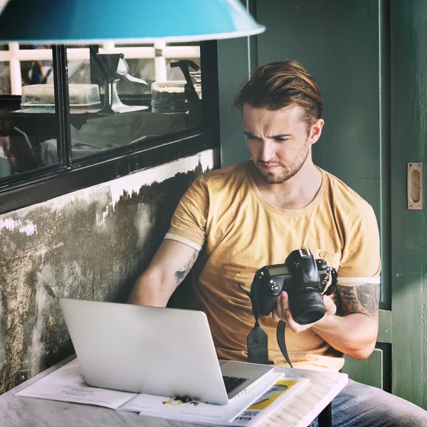 Homme avec caméra à la recherche à l'ordinateur portable — Photo