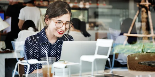 Kvinne som bruker bærbar datamaskin på kafe – stockfoto