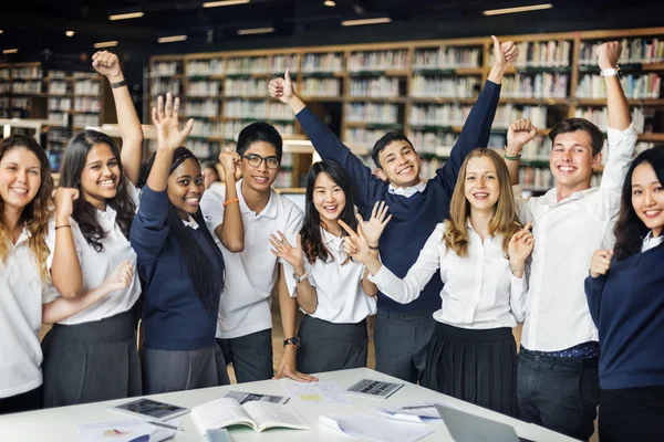 Estudantes felizes na biblioteca universitária — Fotografia de Stock