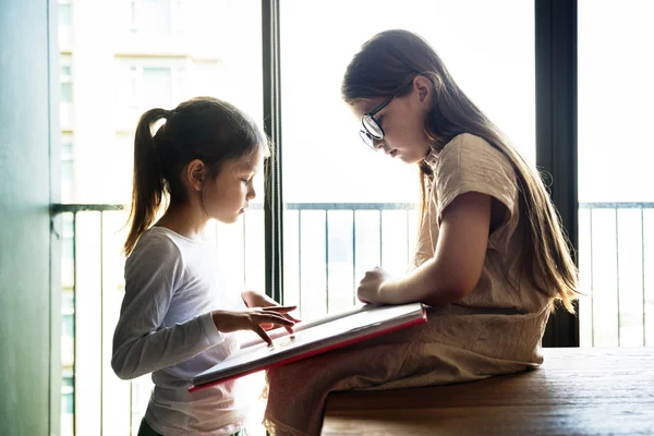 Hermanas leyendo un libro juntas —  Fotos de Stock