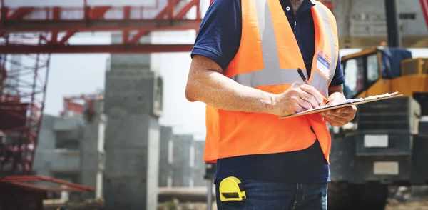 Travailleur de la construction regardant le plan du bâtiment — Photo