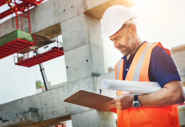 Travailleur de la construction regardant le plan du bâtiment — Photo