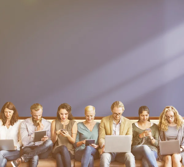 Menschen sitzen mit digitalen Geräten hintereinander — Stockfoto