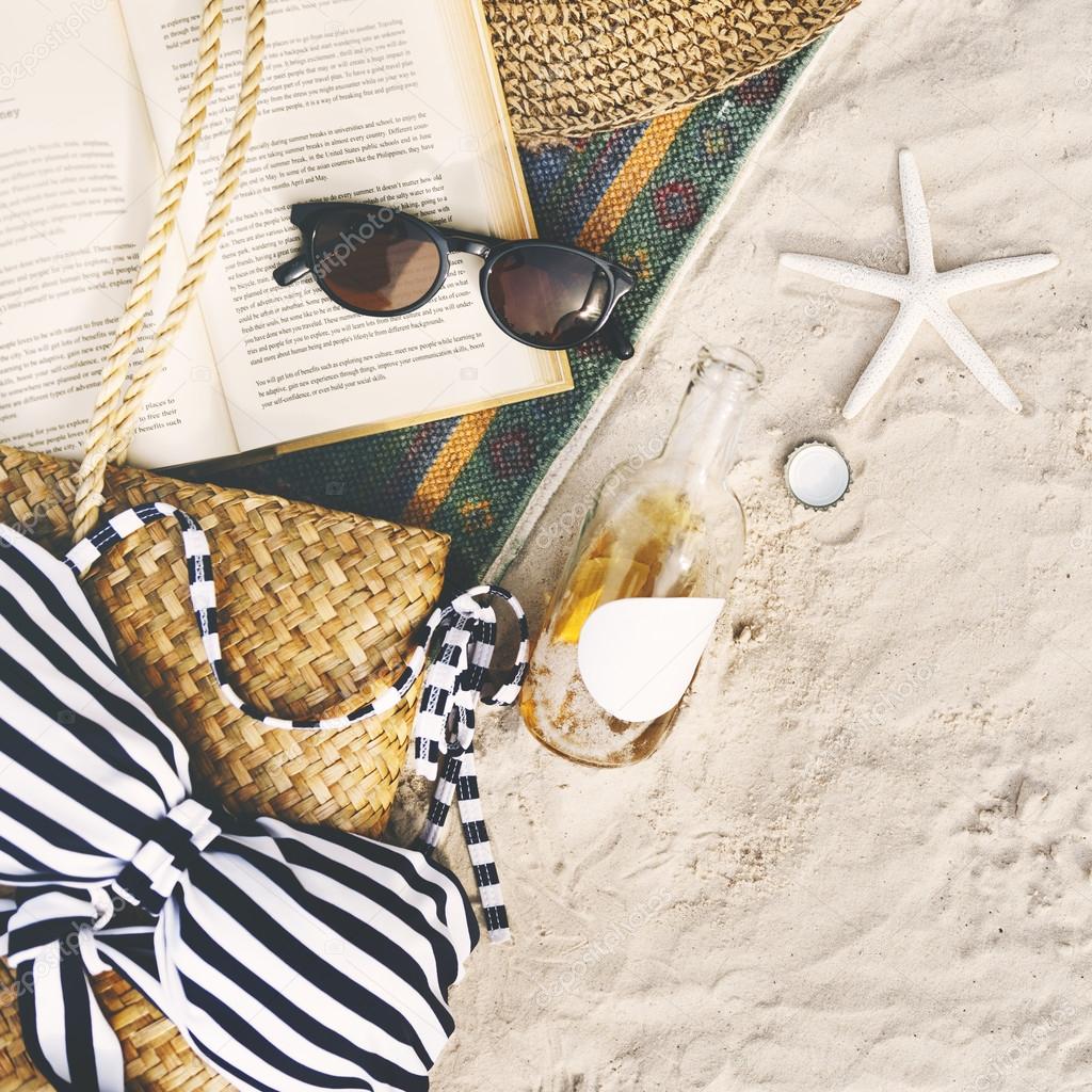 Beach sand with blanket and book