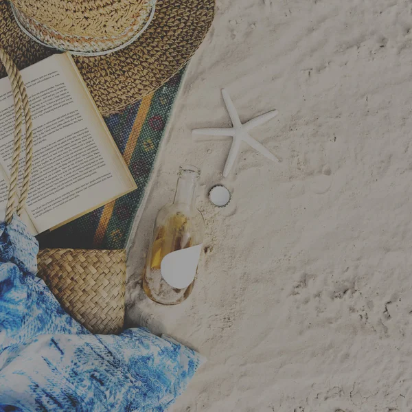 Beach sand with blanket and book — Stock Photo, Image