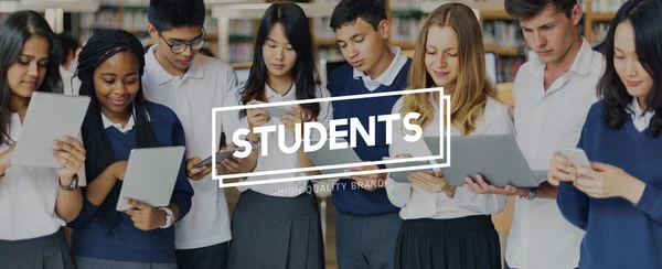 Estudantes que navegam aparelhos digitais — Fotografia de Stock